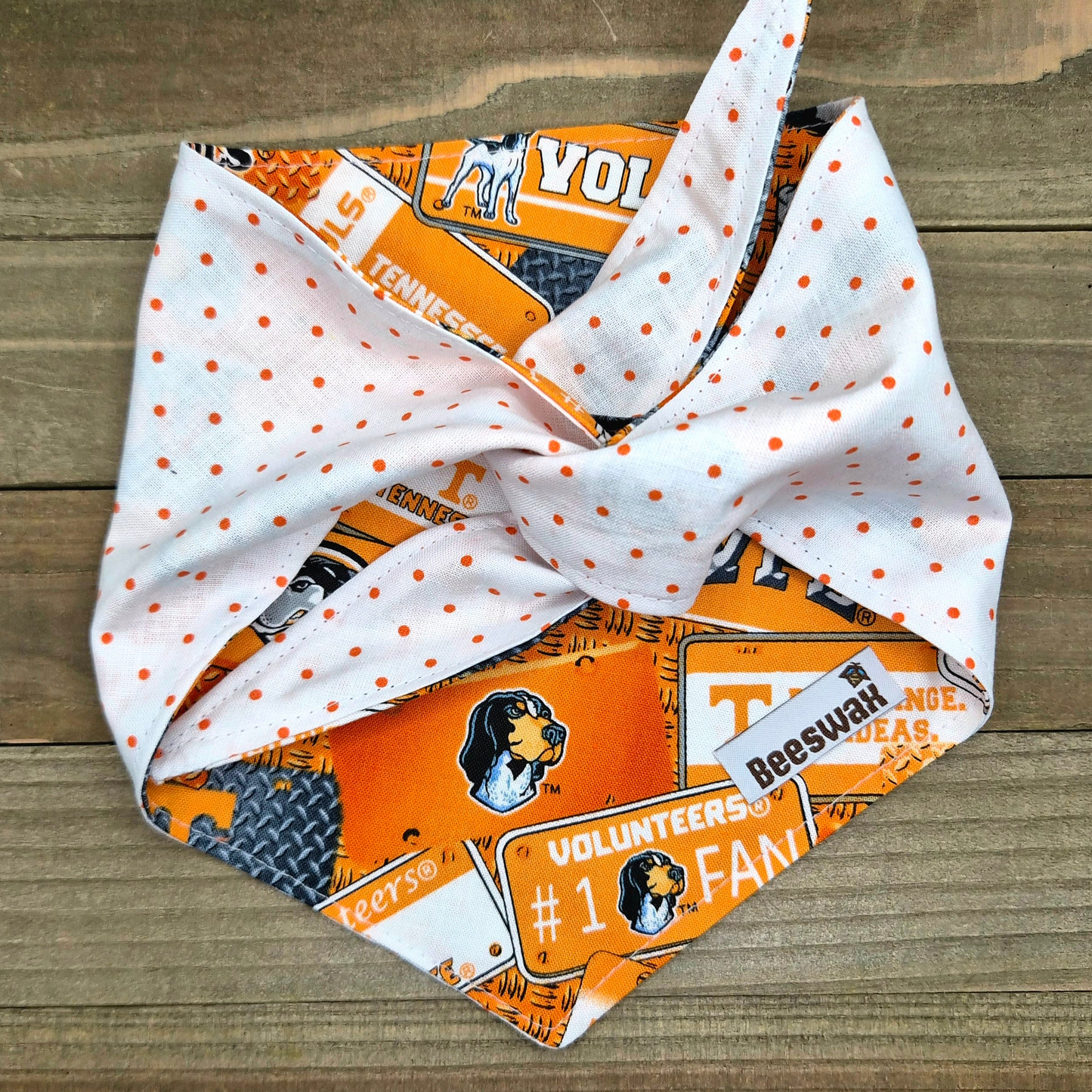a white bandana with orange polka dots, adorned with various logos and text related to the Tennessee Titans football team.