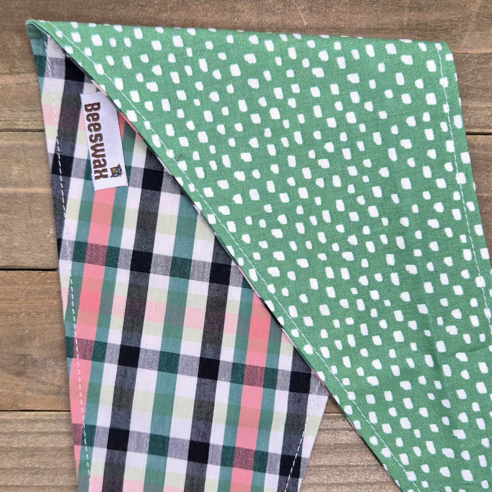 a green and white polka dot pattern on a fabric, with a plaid pattern underneath.