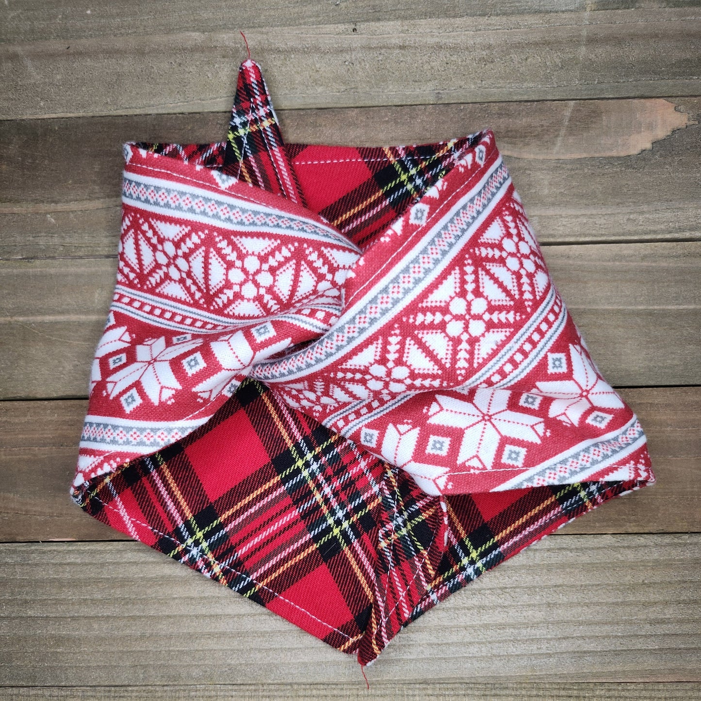 Red and black plaid fabric with white patterns on a wooden surface