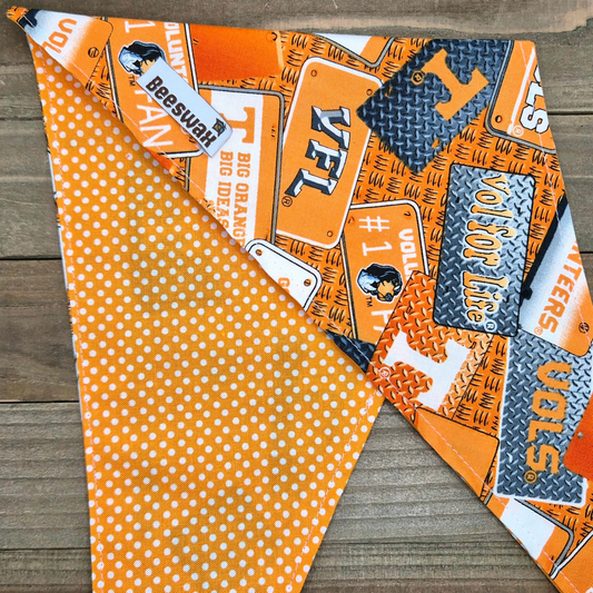 a colorful fabric with various patterns and designs, including a polka dot pattern, a repeating pattern of orange and white, and a pattern of orange and black.