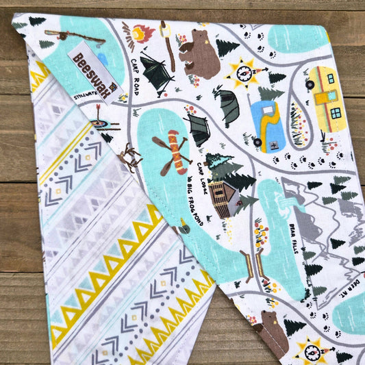 a colorful and detailed fabric with various illustrations and patterns, including camping scenes, animals, and geometric shapes.