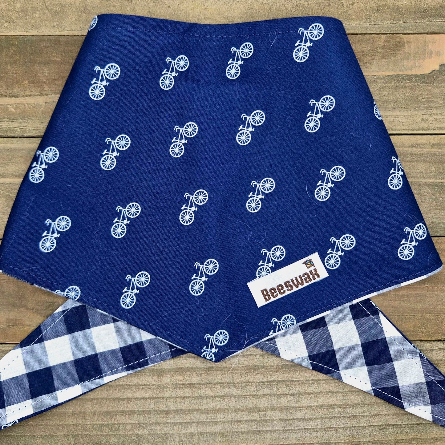 a blue fabric with a white bicycle pattern, and there is a white label with text on it.