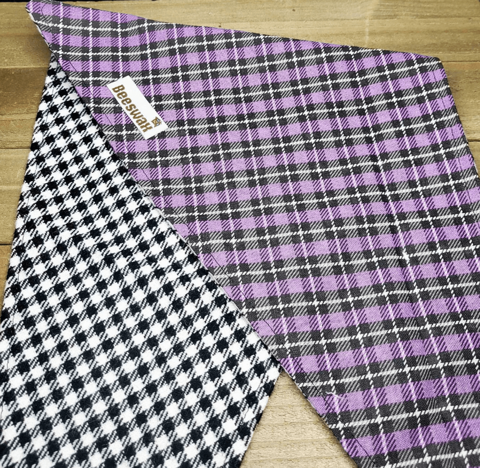 a purple and black plaid fabric with a checkered pattern, placed on a wooden surface.