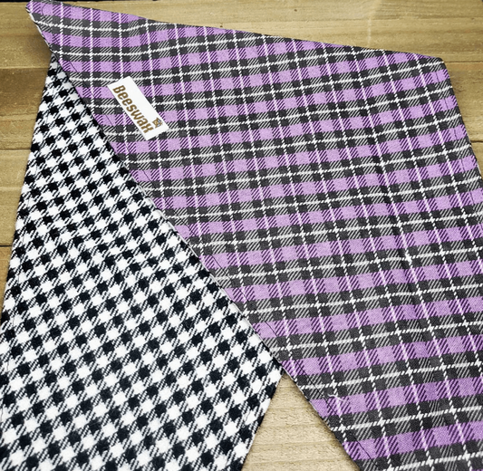 a purple and black plaid fabric with a checkered pattern, placed on a wooden surface.