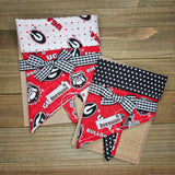 two red and white fabric items with the word "BULLDOG" printed on them, placed on a wooden surface.