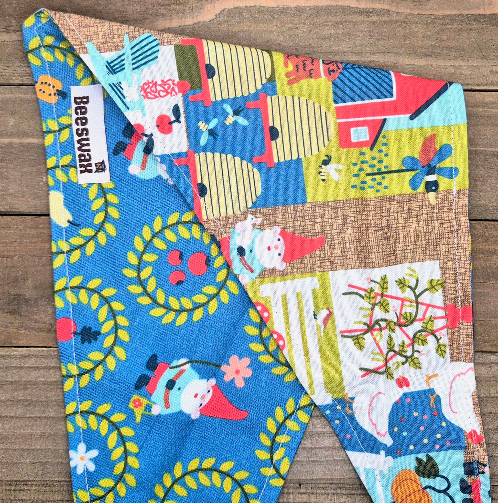 a colorful fabric with various patterns and designs, including gnomes, flowers, and other whimsical elements.